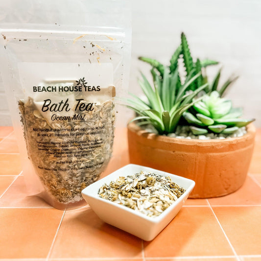 Bath Tea Ocean Mist packaging with a bowl of tea leaves and a potted plant on a tiled surface.