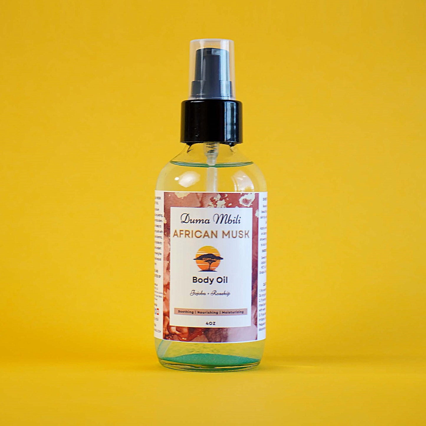 Body oil spray bottle with label on a yellow background
