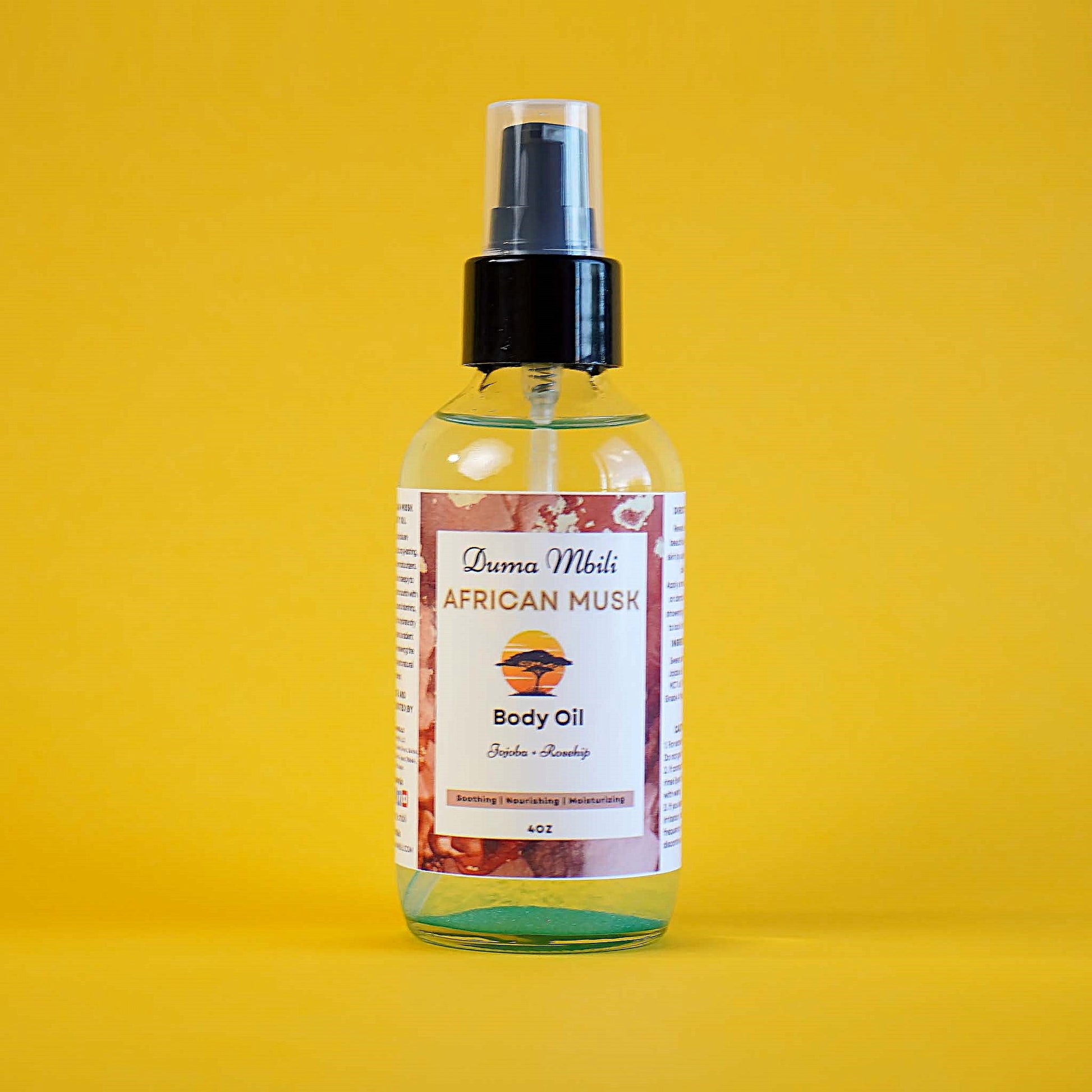 Body oil spray bottle with label on a yellow background