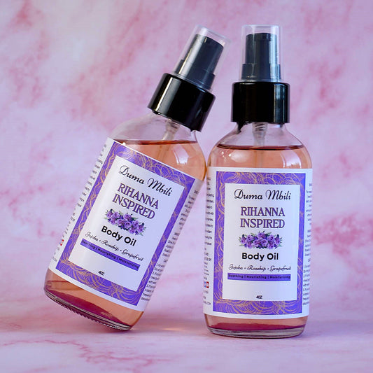 Two bottles of Rihanna Inspired body oil on a pink marble background