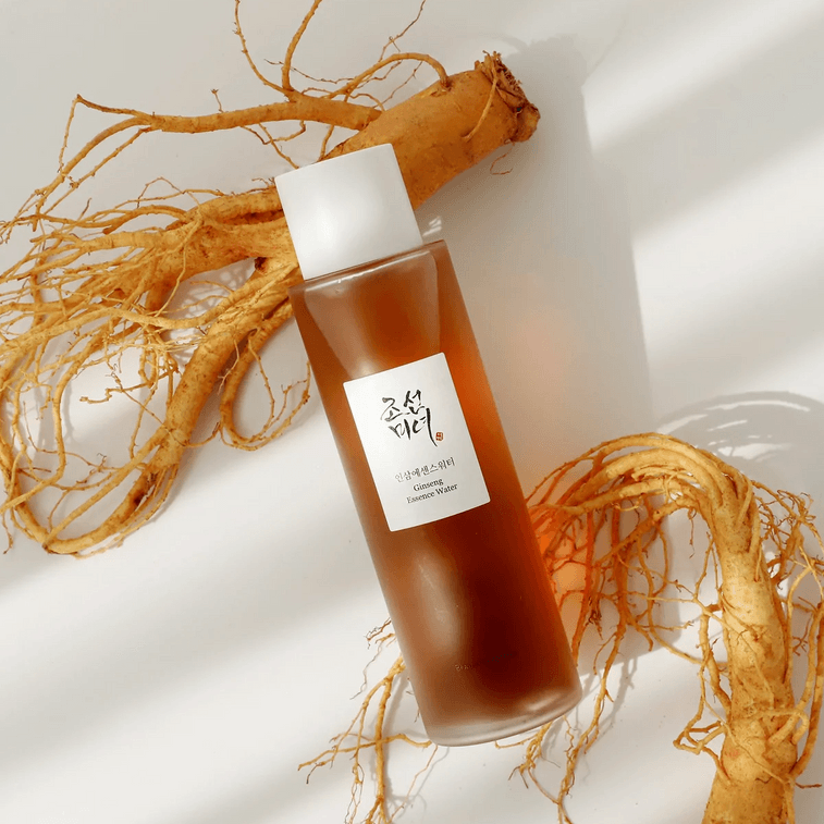 Bottle of skincare product with ginseng root on a light background