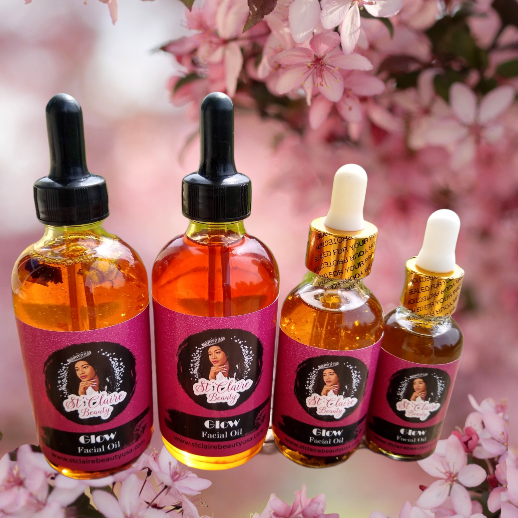 Four bottles of facial oil with droppers against a pink floral background