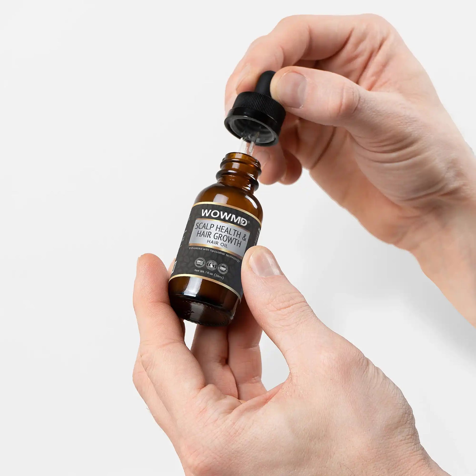 Hand holding a dropper bottle labeled 'WOWND' against a light gray background