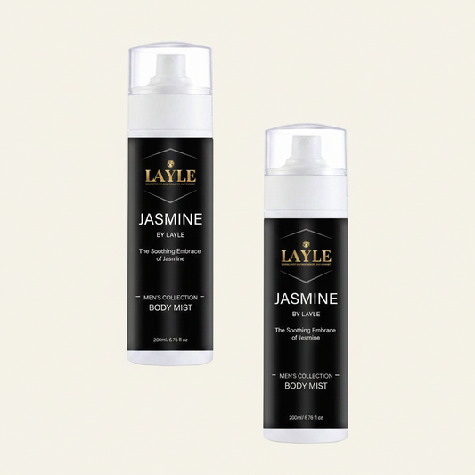 Two bottles of Layle Jasmine by Layle Men's Collection Body Mist on a light cream background. One bottle is standing upright on its side, and the other is standing upright, both showing the black label with gold and white text.
